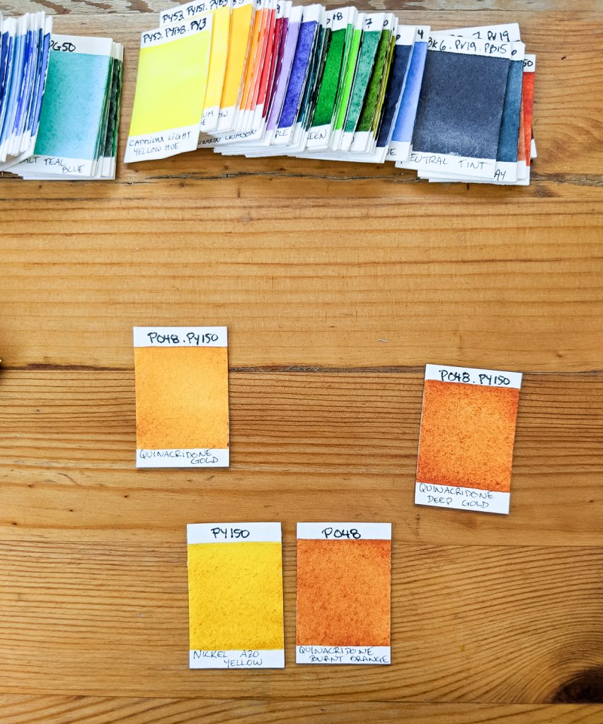 Swatches of paints from Daniel Smith, Nickel Azo Yellow, Quinacridone Orange, Quinacridone Gold, Quinacridone Deep Gold.